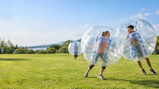 people playing an outdoor bumper ball game on a clean grassy field in bright daylight