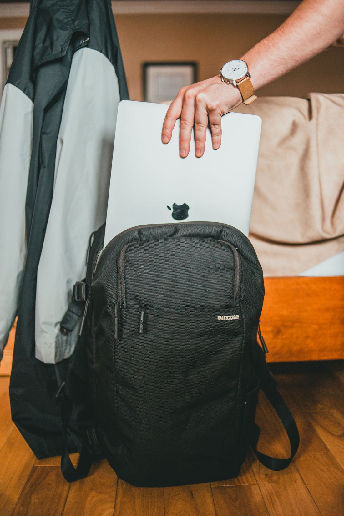 Person placing a laptop inside a backpack for organized digital nomad carry