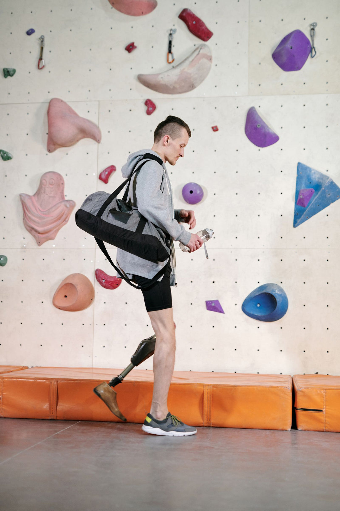 Man carrying a gym bag and water bottle after a workout