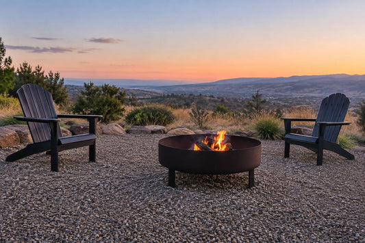 Round wood-burning fire pit with a small controlled flame on an open gravel patio at dusk