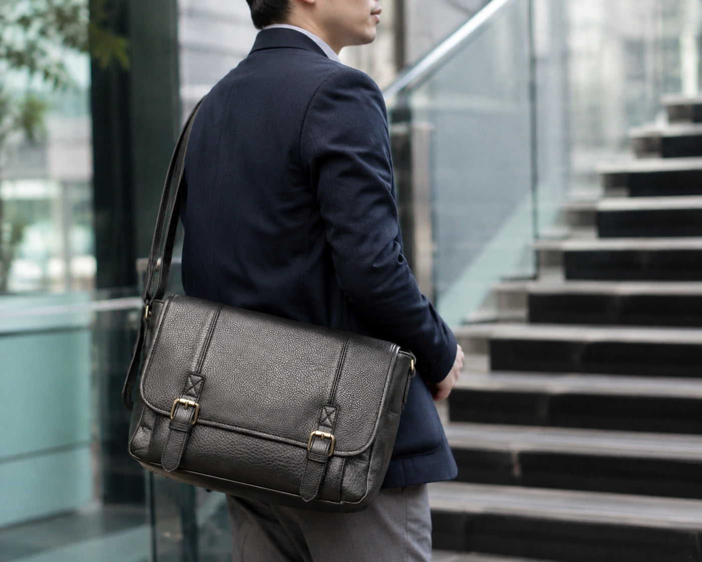 Black full-grain leather large messenger bag worn by model